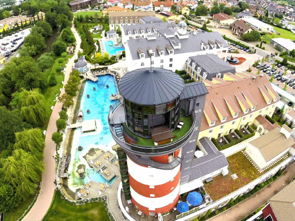 Luftaufnahme eines großen Hotel-Resorts mit mehreren Pools und Gebäudekomplexen, eingebettet in viel Grün.